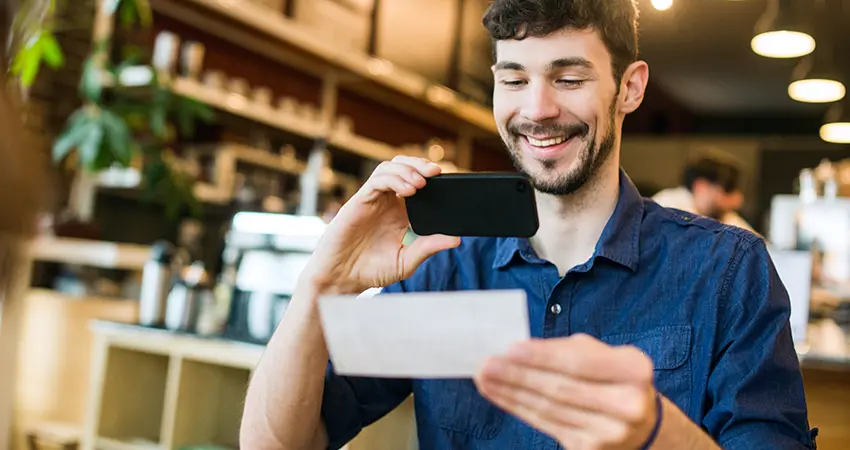 man taking picture of check