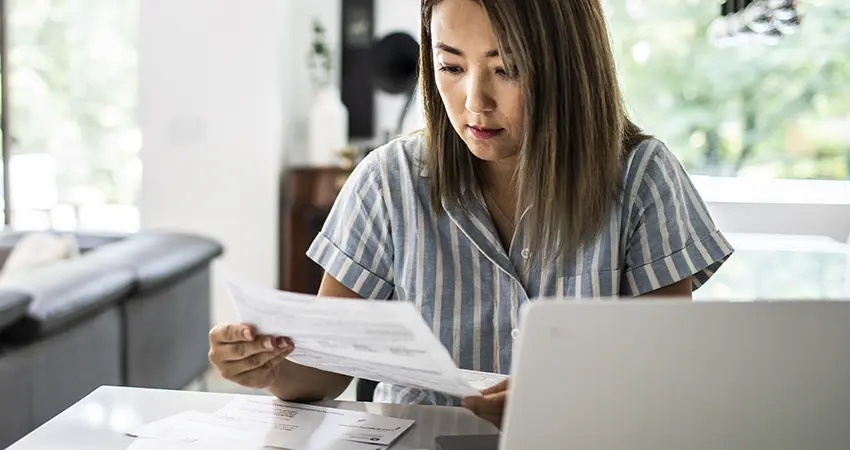 woman paying bills on a laptop